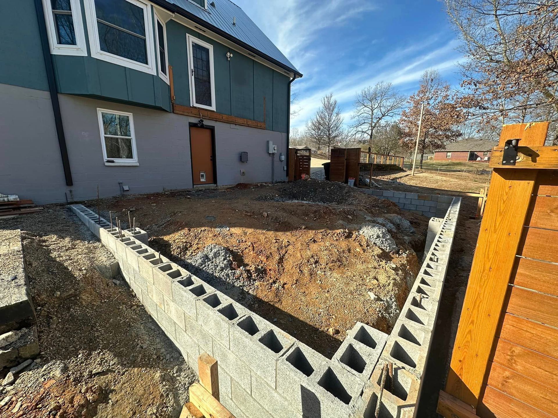 A brick wall is being built in front of a house.