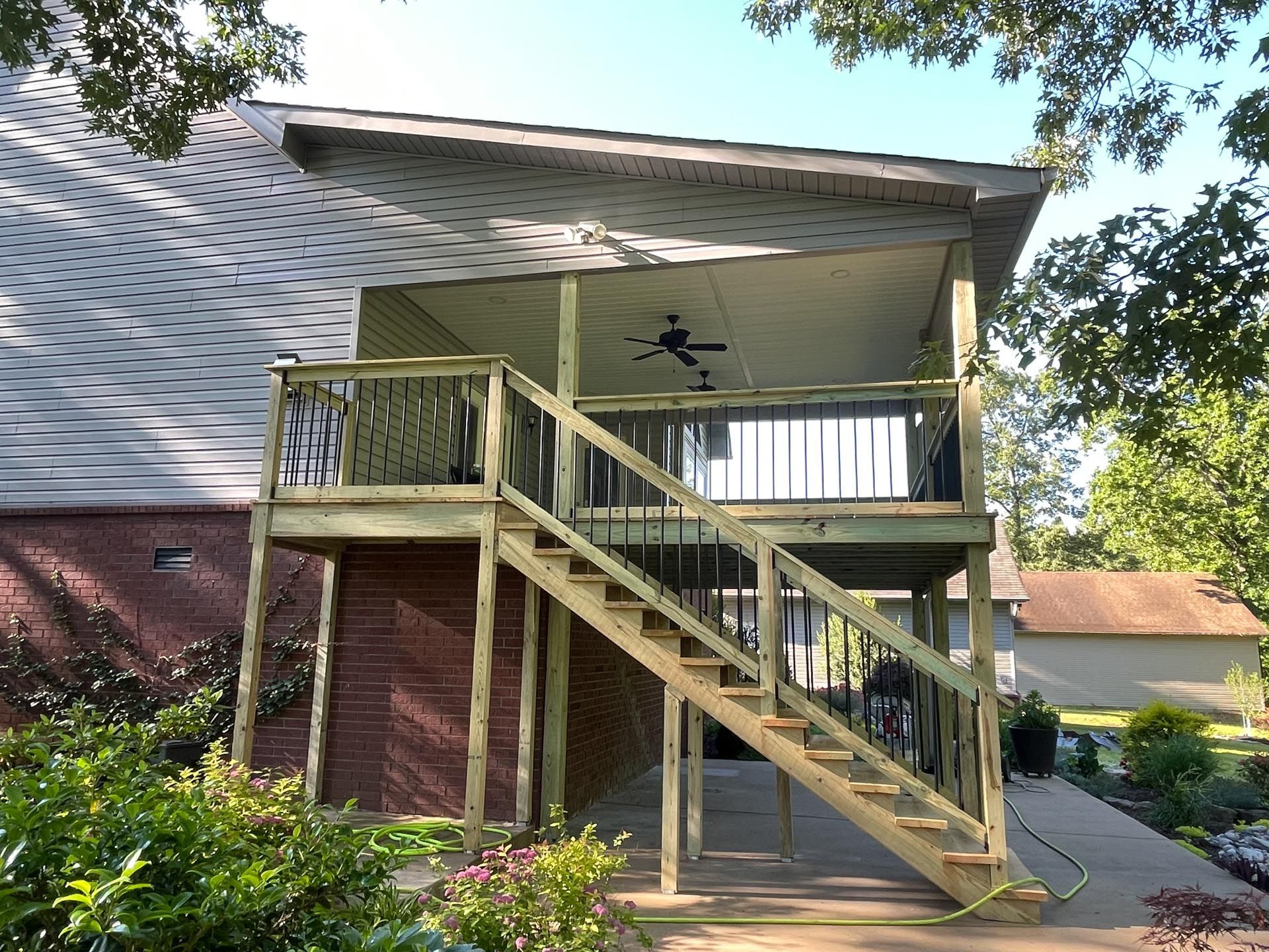 A house with a wooden deck and stairs leading up to it.