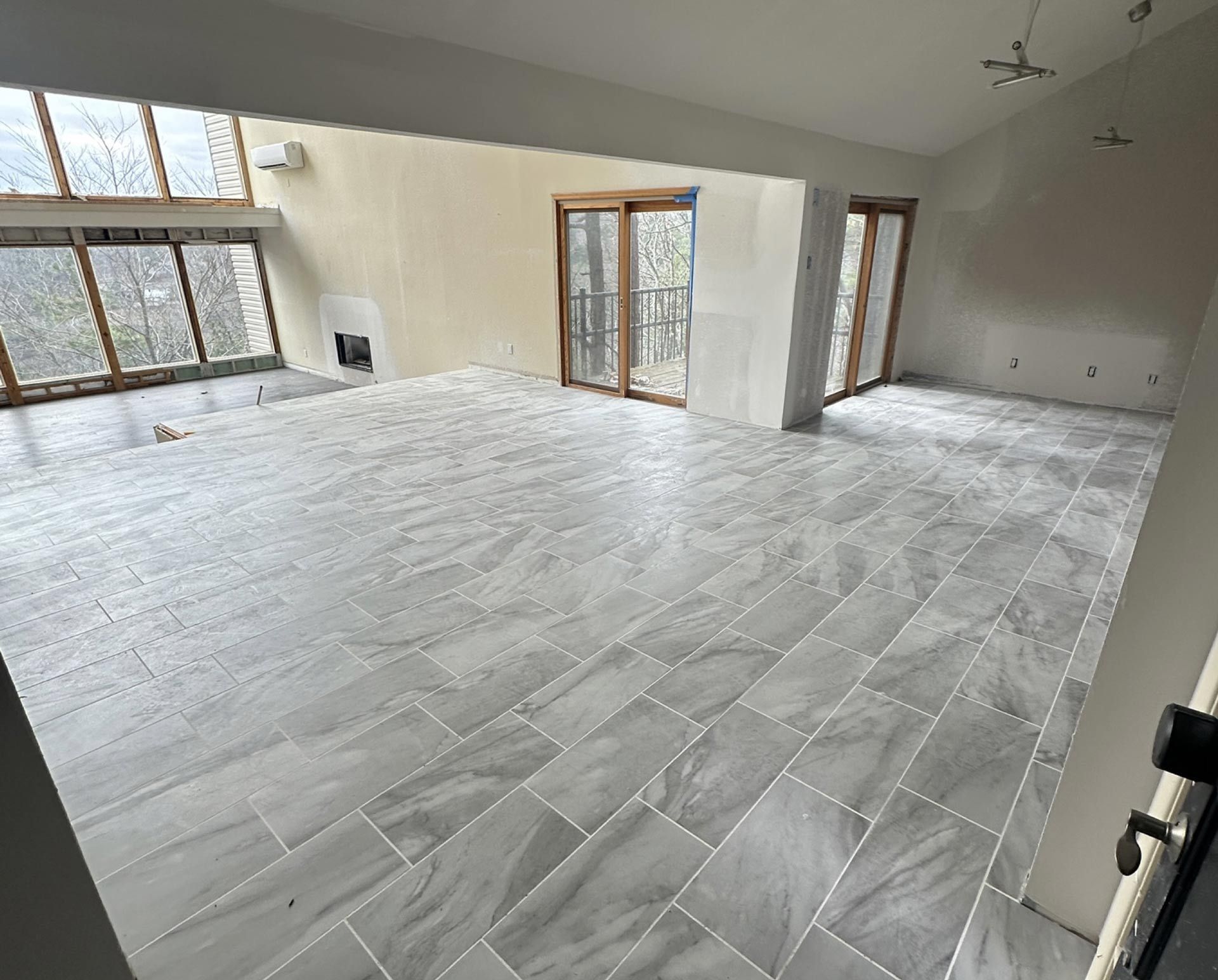 A large empty room with tile floors and sliding glass doors.