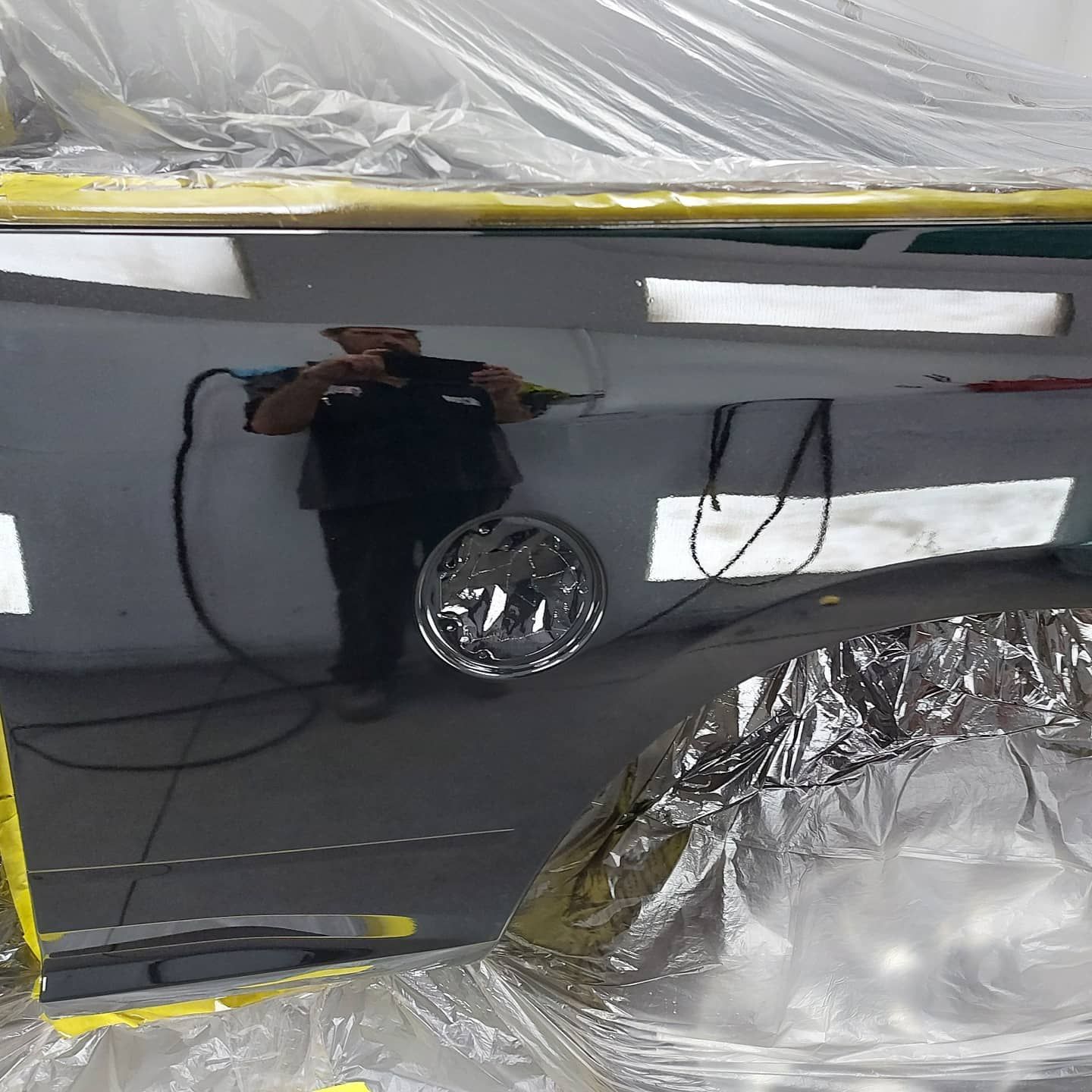 A man is taking a picture of his reflection in a mirror.