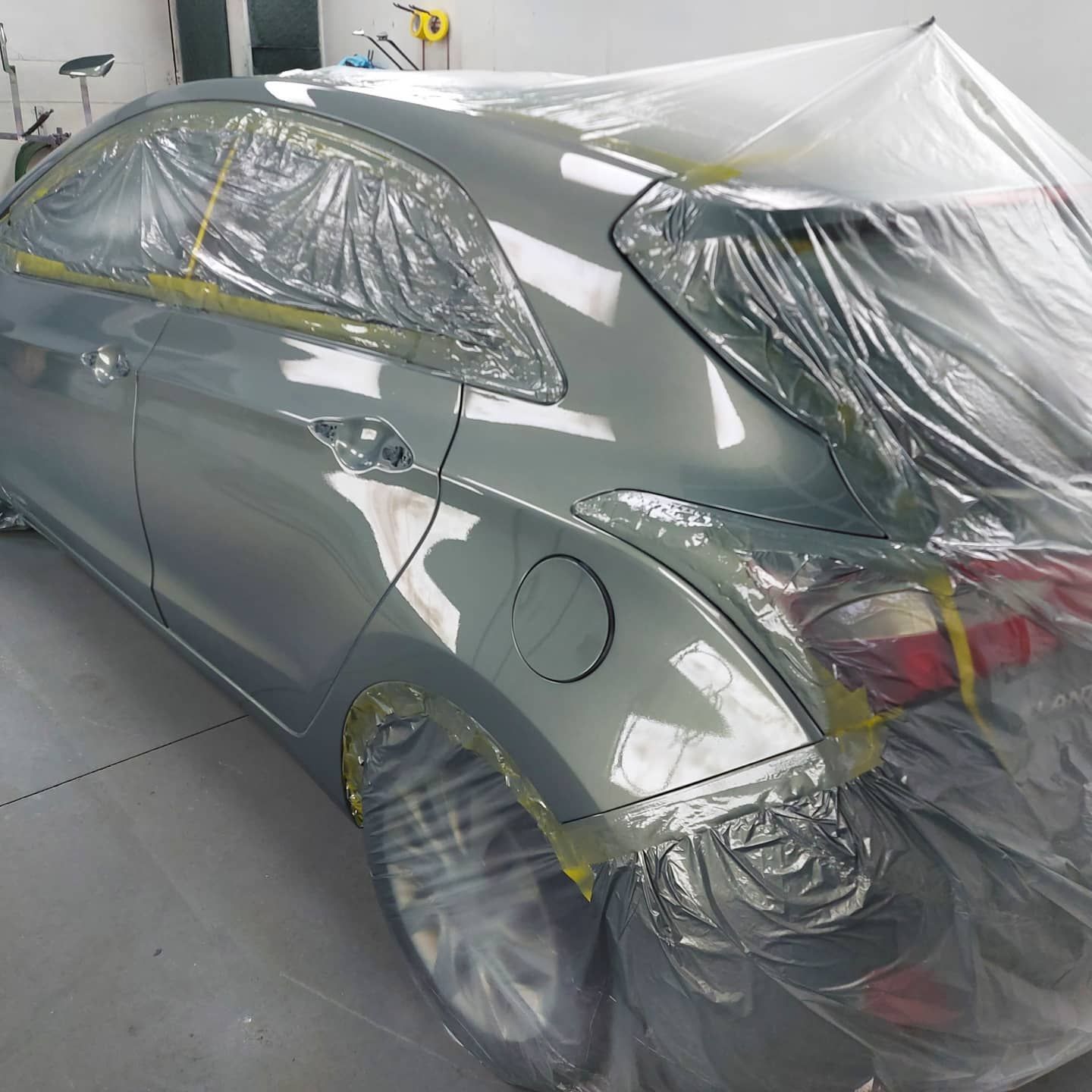 A car is wrapped in plastic and ready to be painted