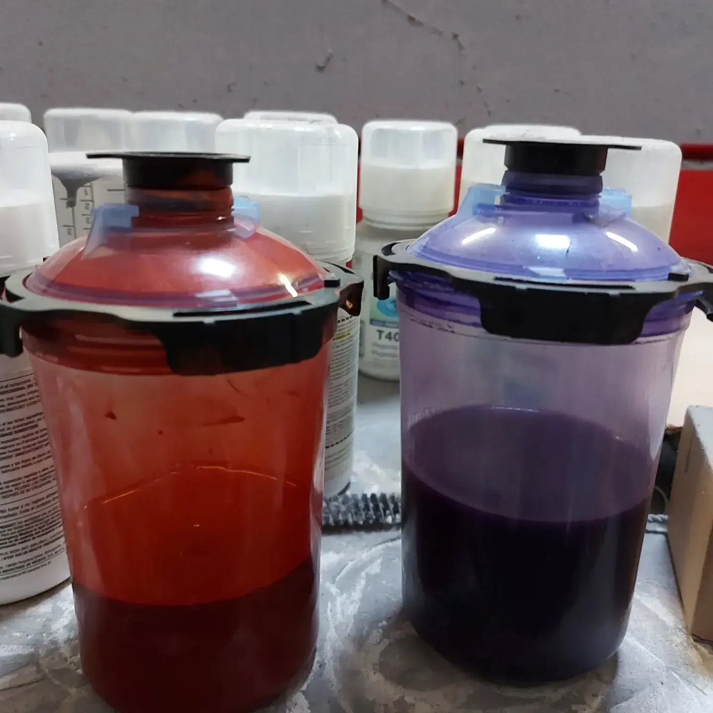 Two plastic cups filled with red and purple liquid