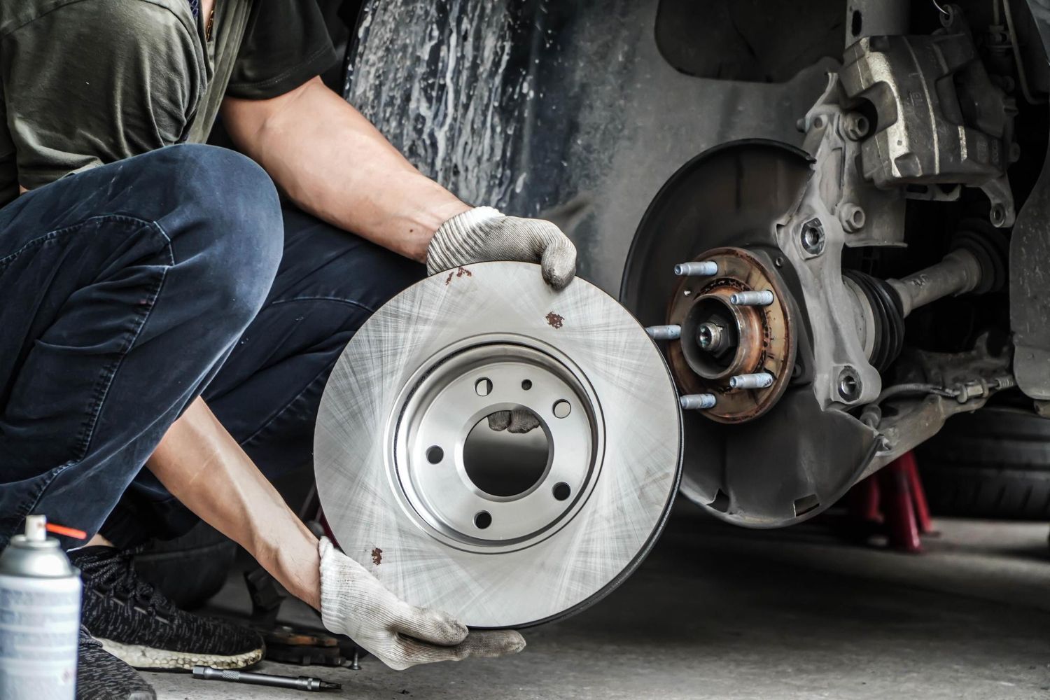 A man is fixing a brake disc on a car.