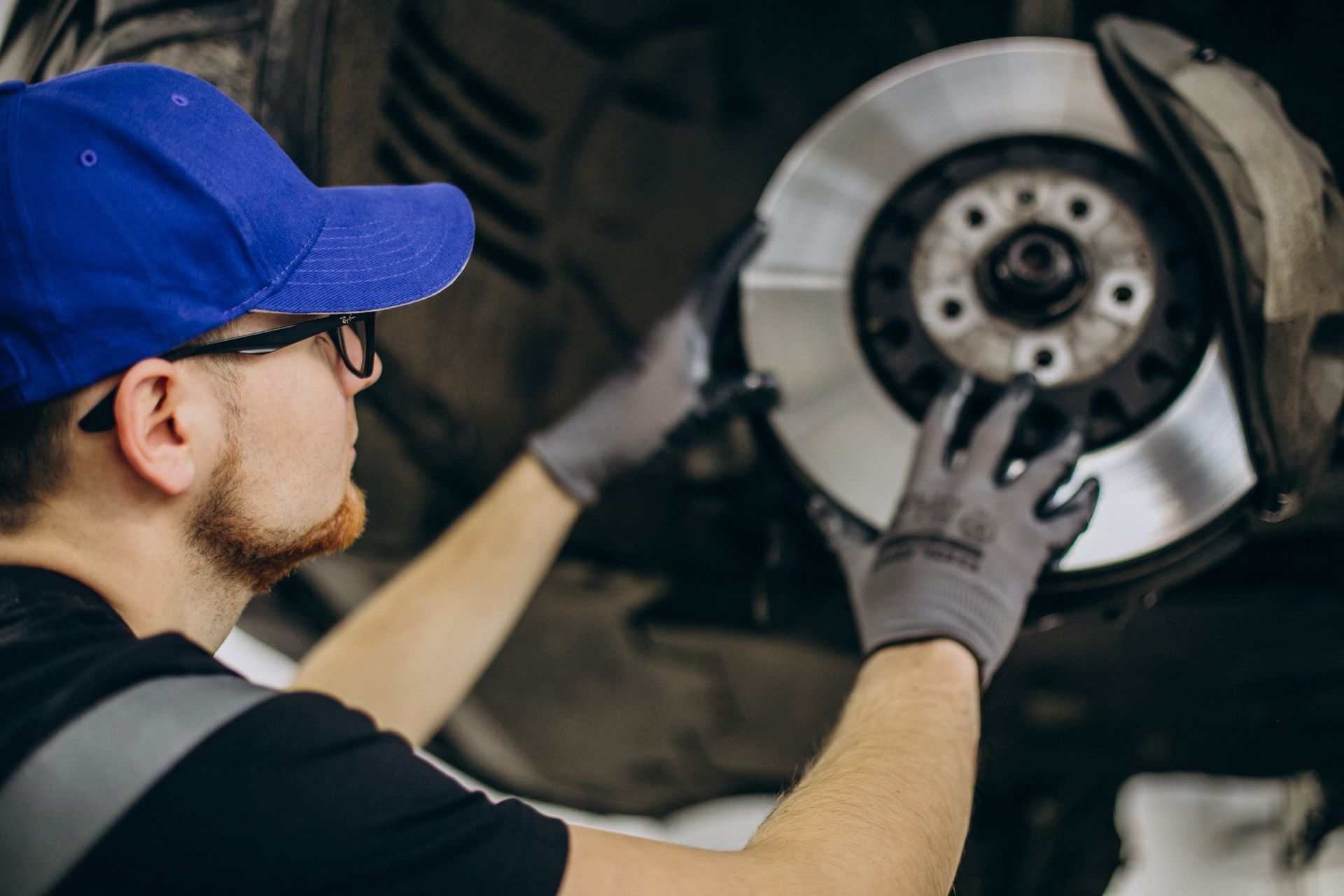 A man is working on a brake disc on a car.