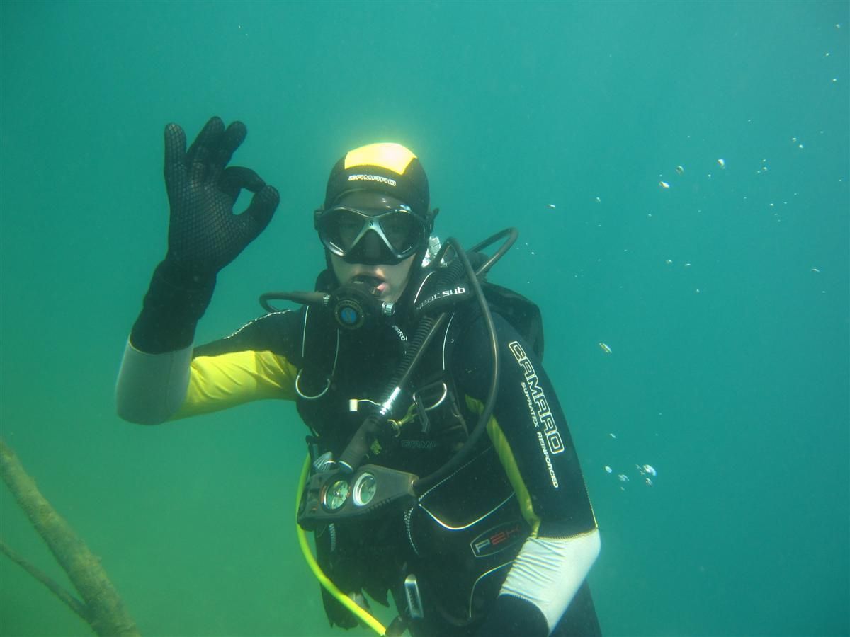 Een duiker geeft het ok-teken in het water
