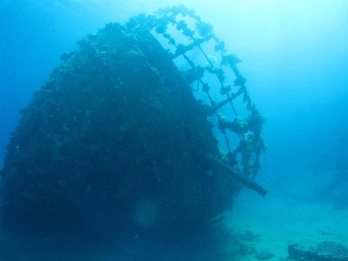 Een groot scheepswrak drijft bovenop een koraalrif in de oceaan.