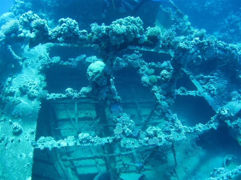 Een scheepswrak midden in een koraalrif in de oceaan.
