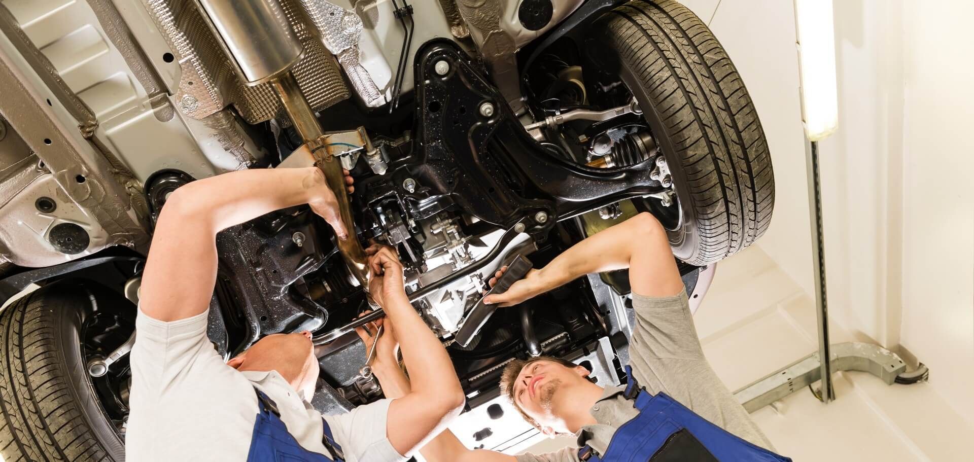 Two mechanics from a reliable fleet maintenance service provider working on a car for a client