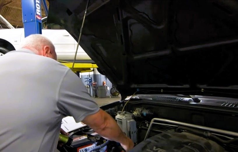 Mechanic performing an engine inspection in a vehicle repair shop