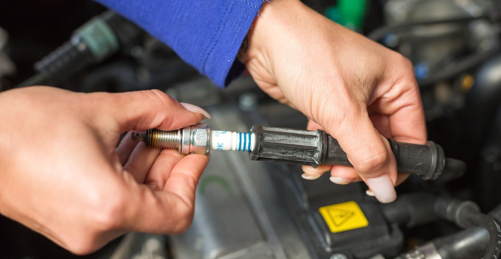 A car mechanic conducting a spark plug replacement