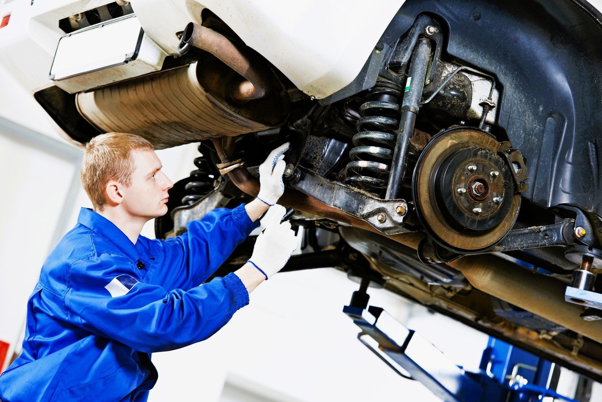 Mechanic checking car suspension system and brakes