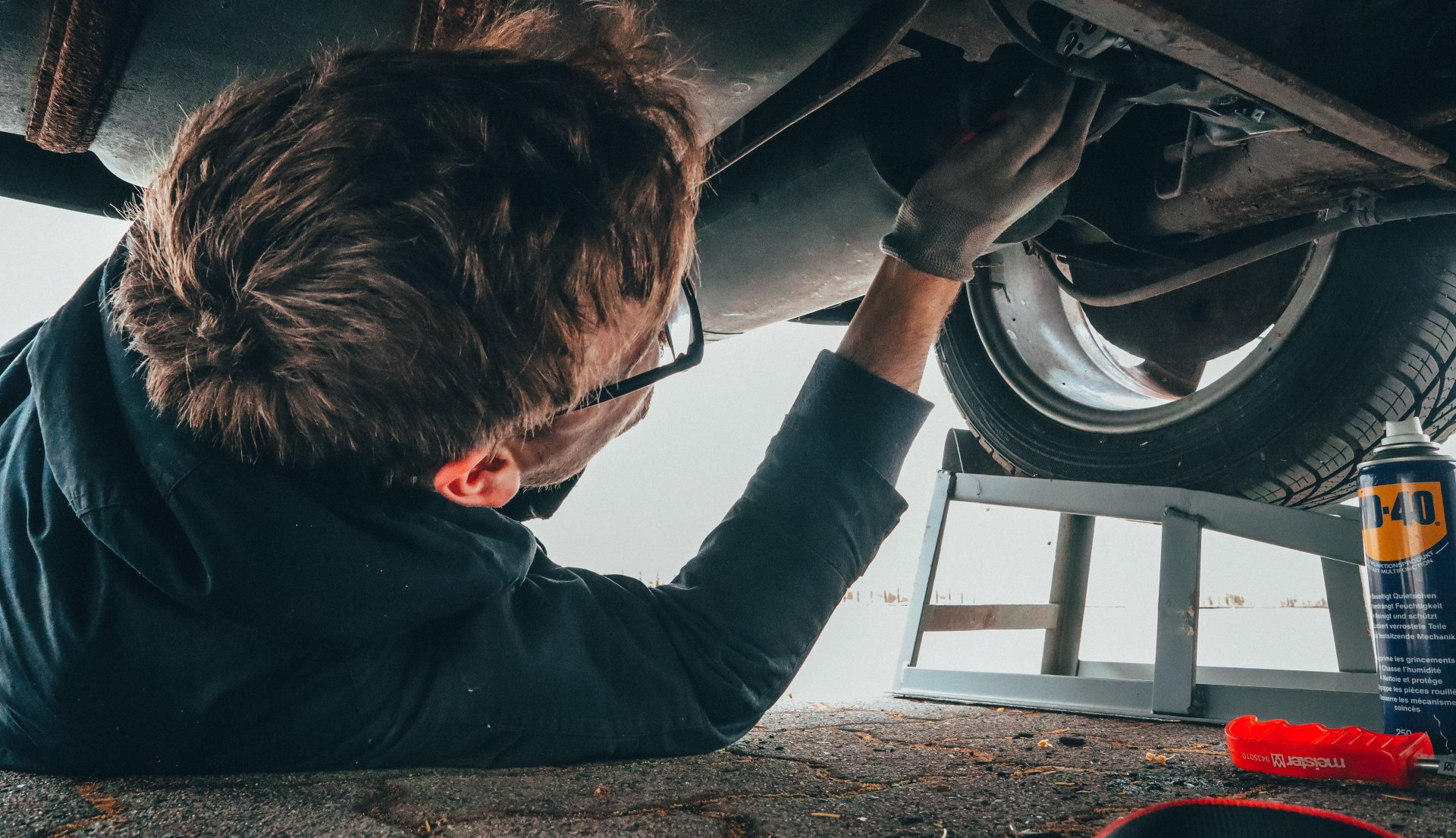 mobile car mechanic working under vehicle