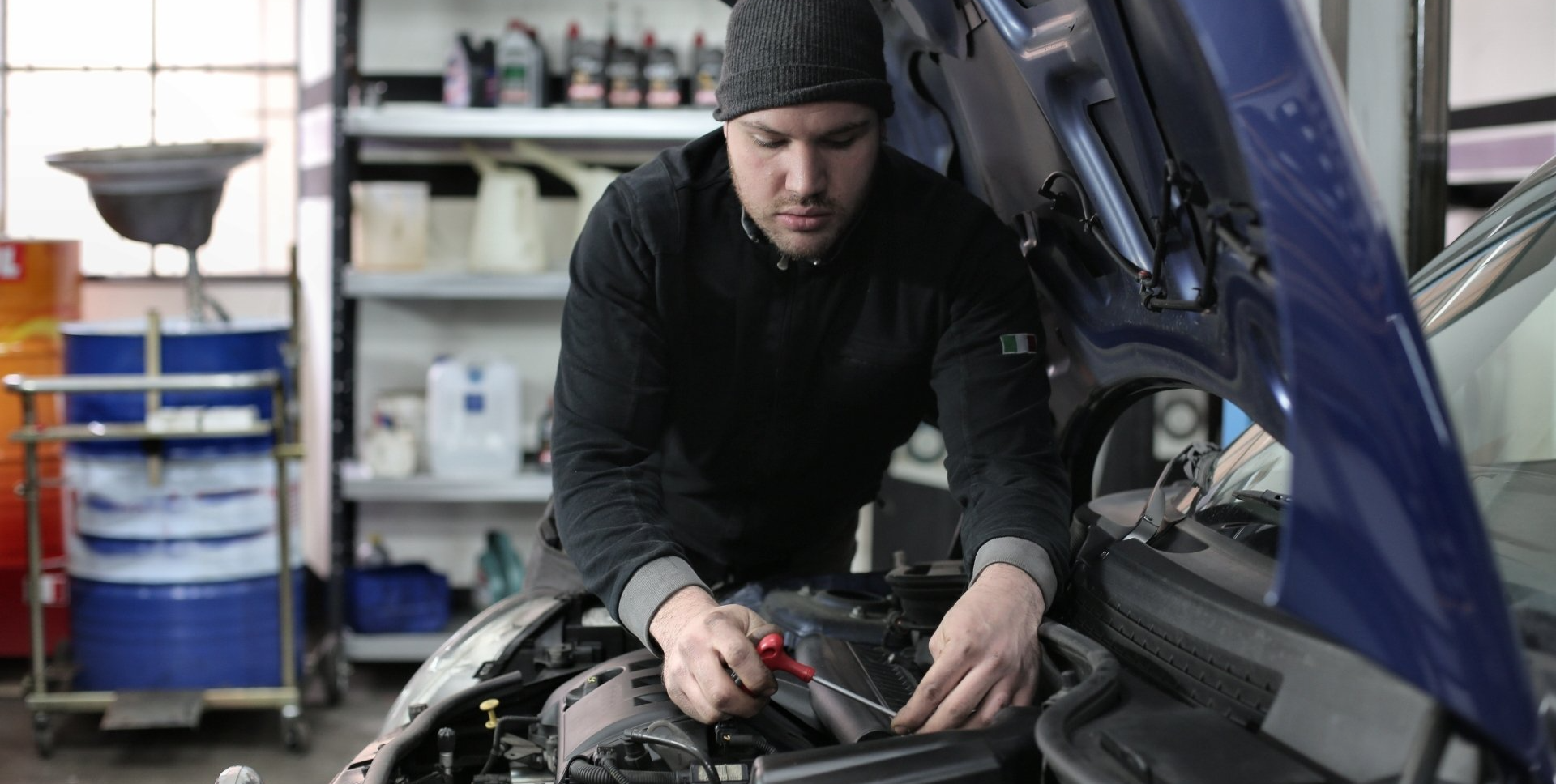 mobile mechanic works on car in garage