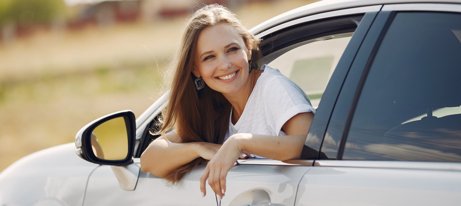 car owner smiling from driver's seat of vehicle