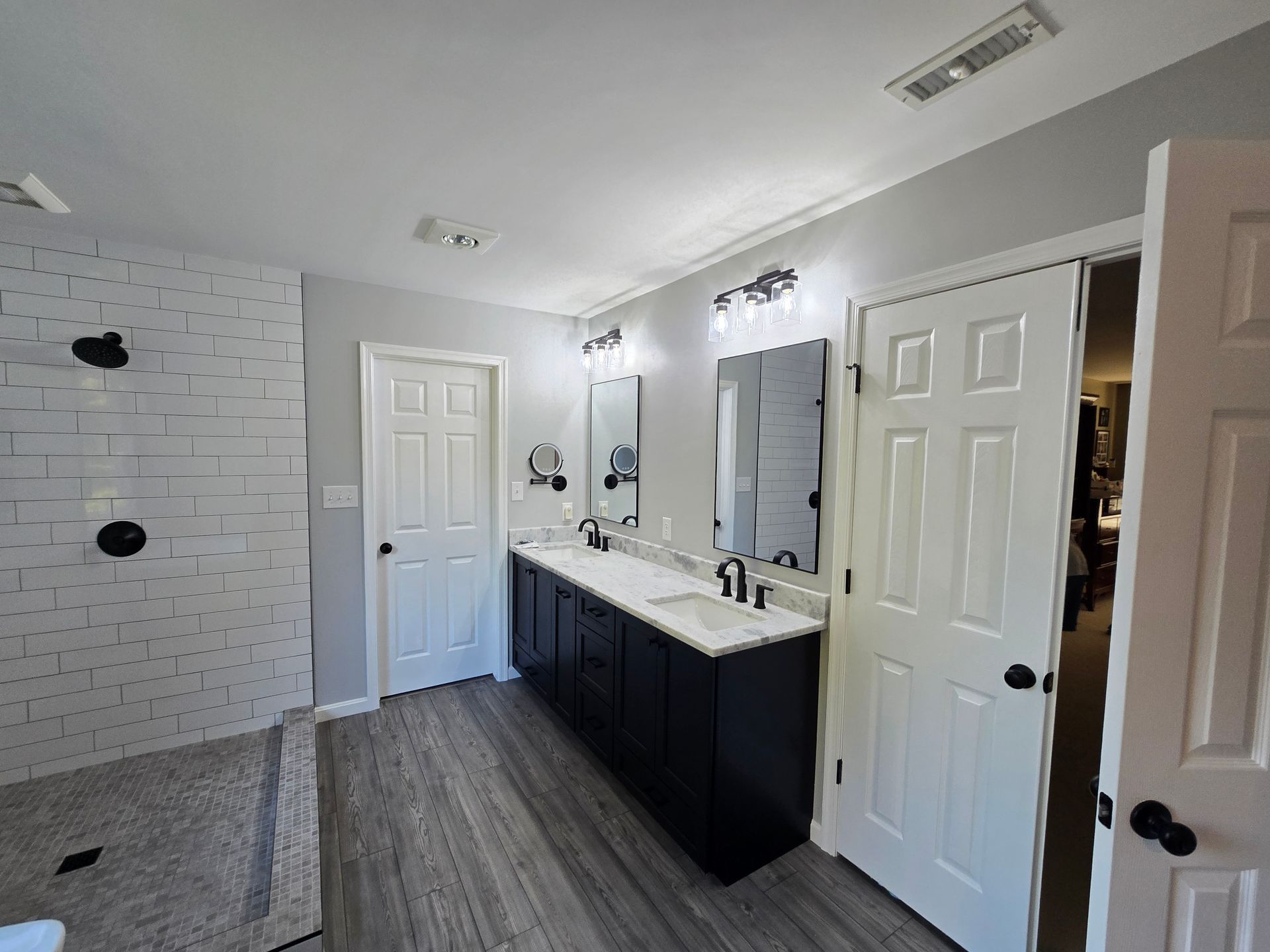 Bathroom with a gray and white color scheme, with a double vanity and a shower.