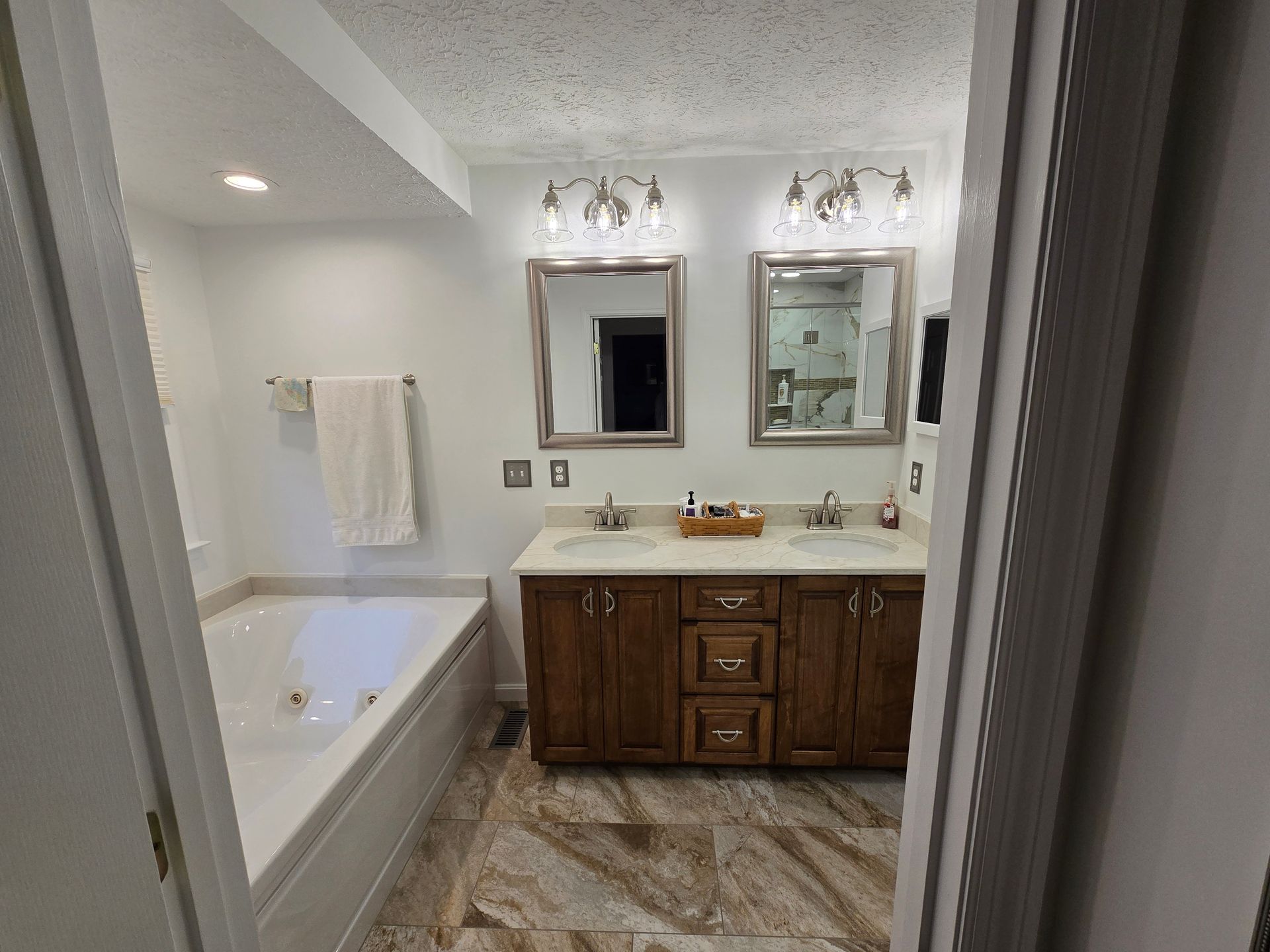 Bathroom with a tub and double vanity with two mirrors.