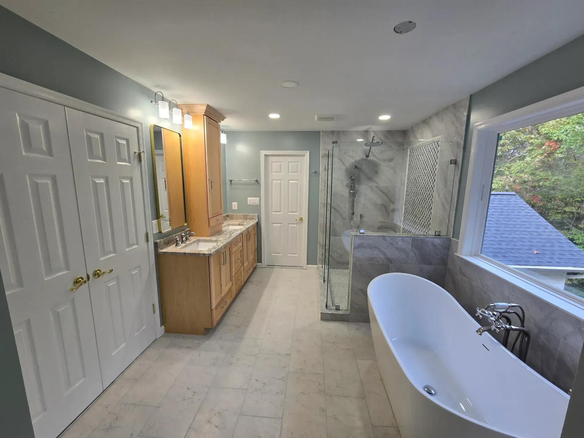 Newly renovated bathroom with a double vanity, soaking tub, and tiled shower.