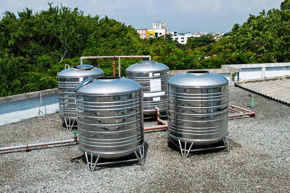 A Group of Stainless Steel Water Tanks Are Sitting on Top of a Roof — Nabiac Water Carriers in Nabiac, NSW