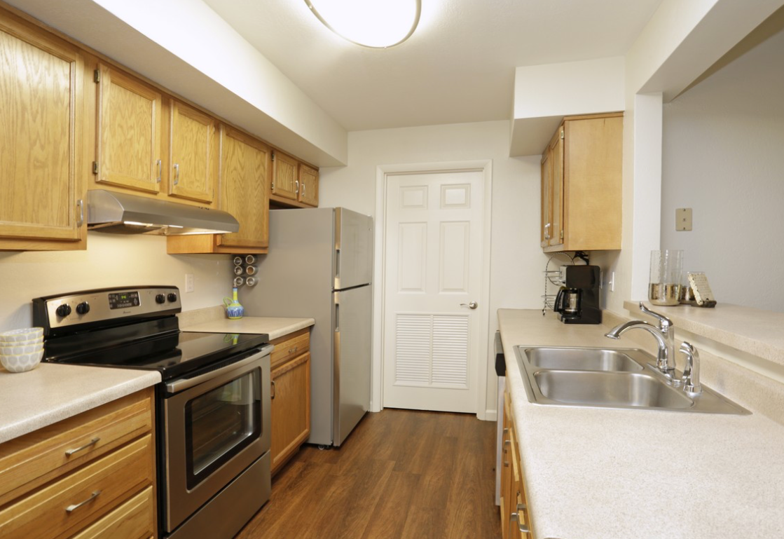 Kitchen with light wood cabinets, stainless steel appliances, and a white countertop.