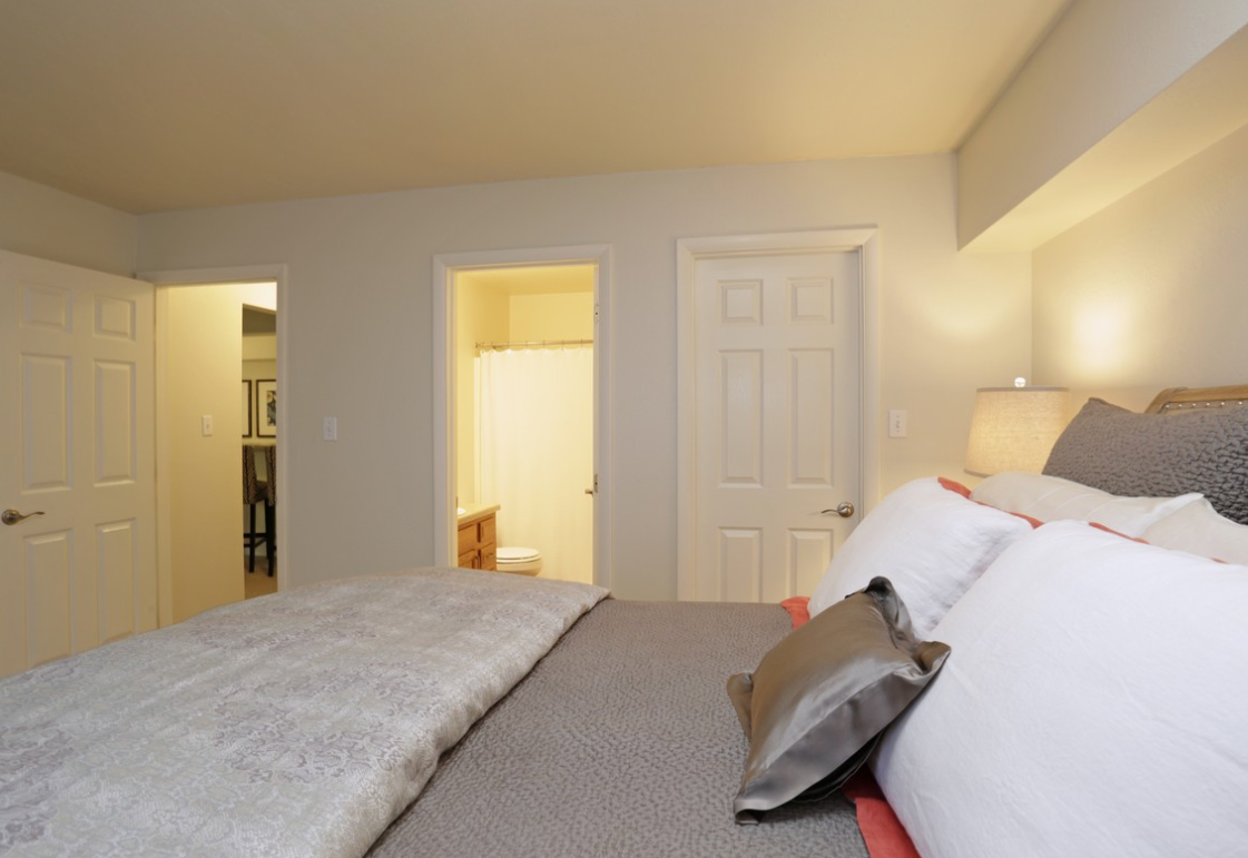 Bedroom with bed, pillows, doorway to bathroom, and closet on left.