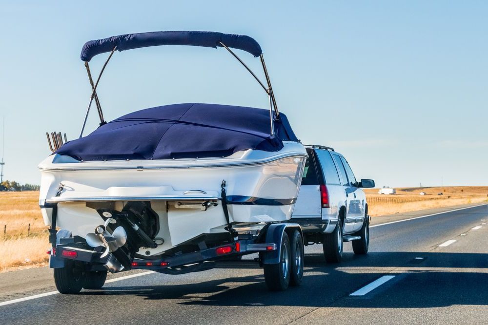 A Boat Is Being Towed By A Truck On A Highway — Torquay & Anglesea Accident Towing Centre In Torquay, VIC