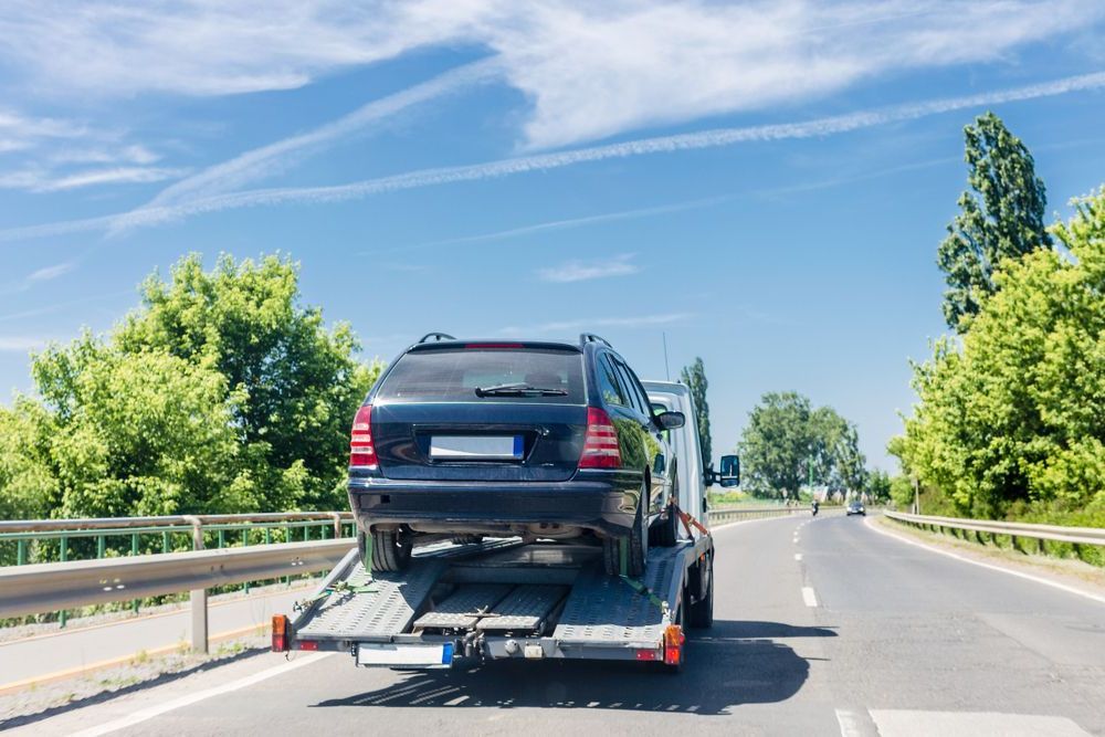 A Car Is Being Towed Down A Highway By A Tow Truck — Torquay & Anglesea Accident Towing Centre In Big Hill, VIC