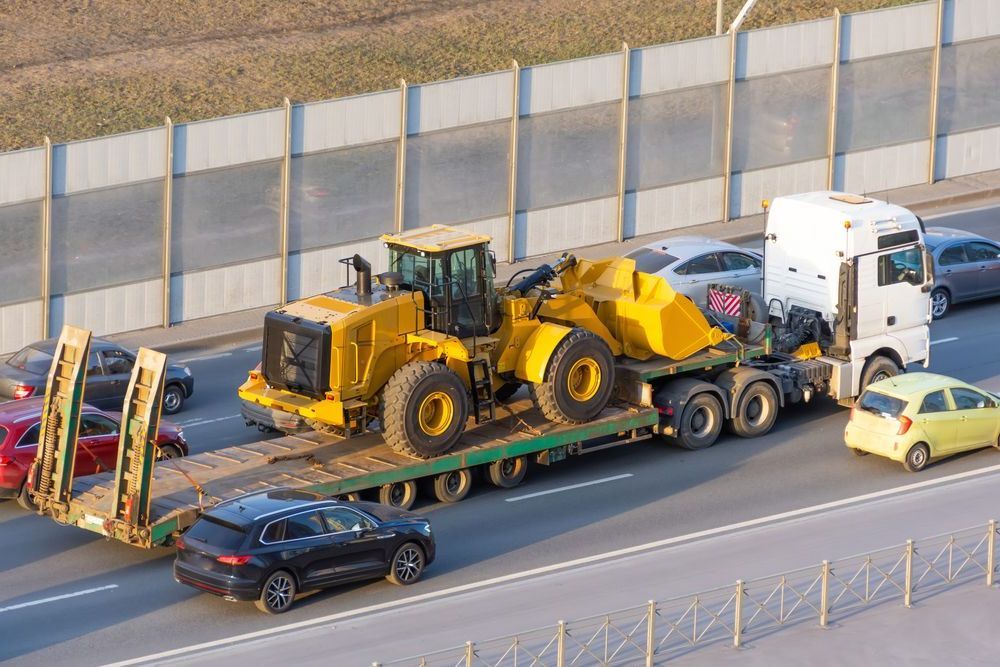 A Truck Is Carrying A Bulldozer On A Trailer On A Highway — Torquay & Anglesea Accident Towing Centre In Colac, VIC