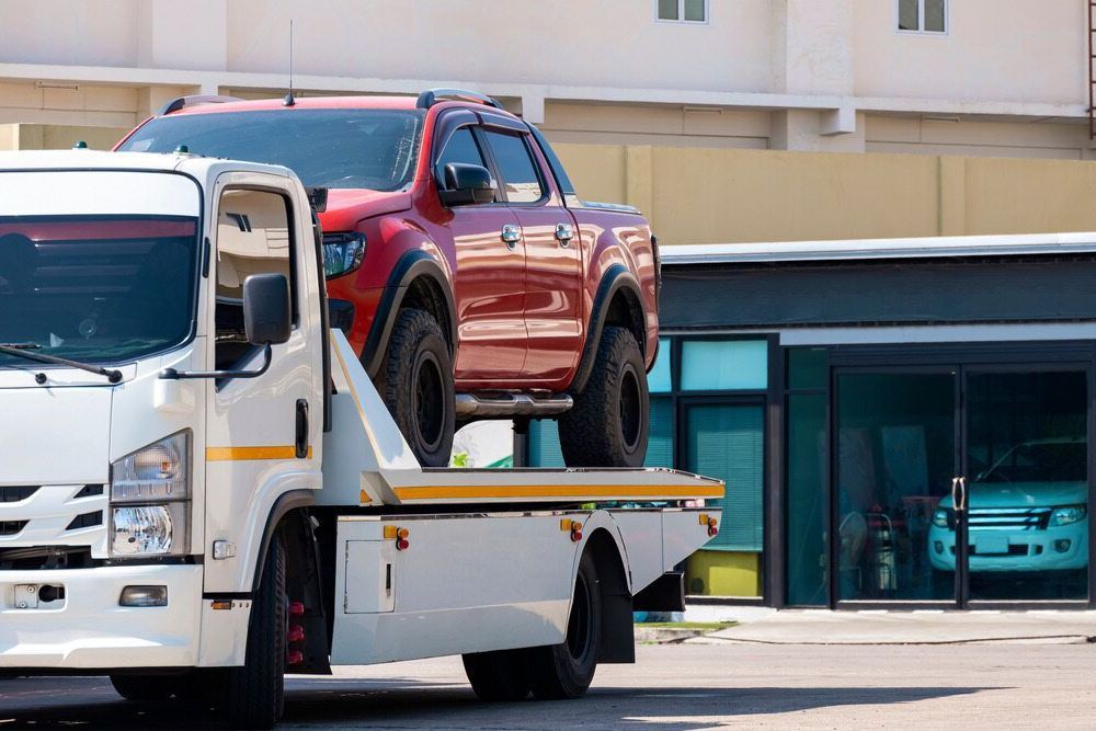A Red Truck Is Being Towed By A Tow Truck — Torquay & Anglesea Accident Towing Centre In Ocean Grove, VIC