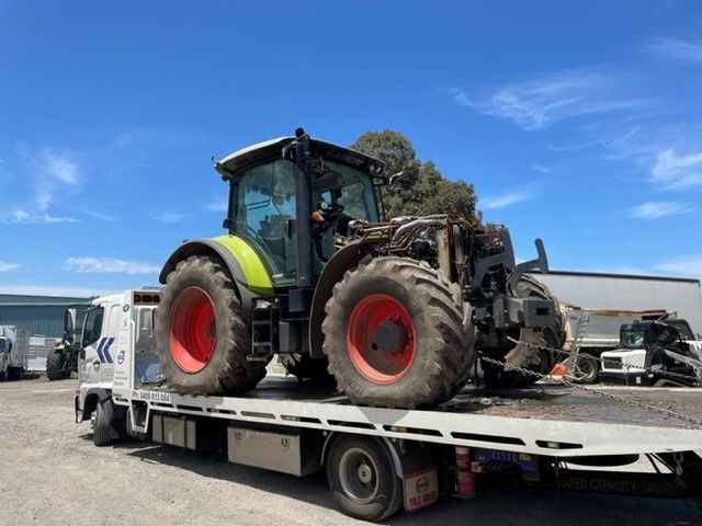 A Tow Truck With A Tractor On The Back Is Parked— Torquay & Anglesea Accident Towing Centre In Torquay, VIC