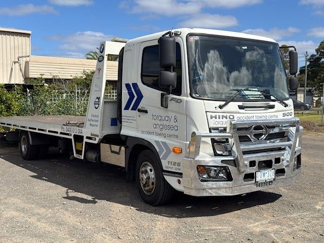 A Tow Truck With A Car On The Back Is Parked— Torquay & Anglesea Accident Towing Centre In Ballan, VIC