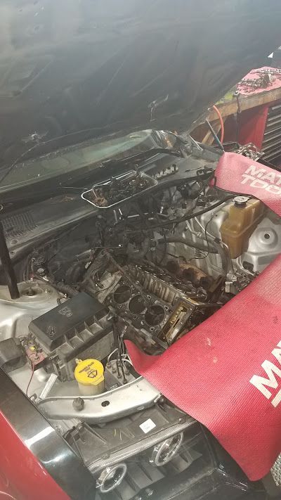 The hood of a car is open and the engine is visible.