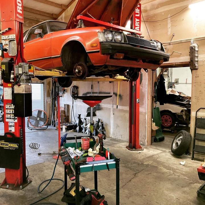 A car on a lift in a garage with a sign that says baby lift