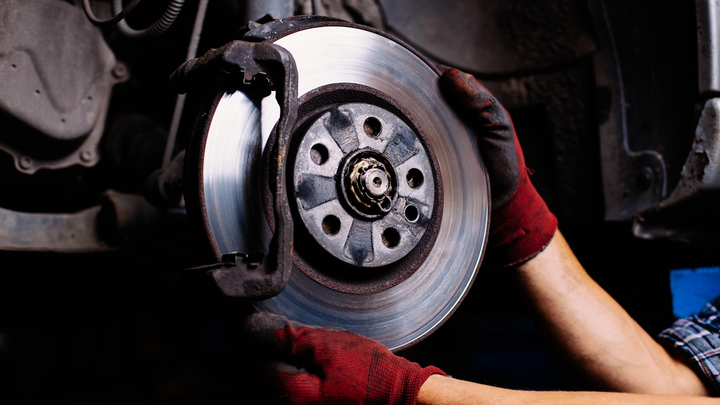 A person is fixing a brake disc on a car.