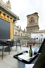 A bottle of champagne is on a tray on a balcony.