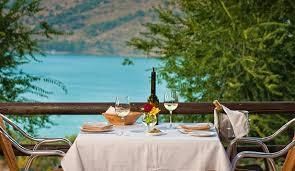 A table set for a dinner with a view of a lake.