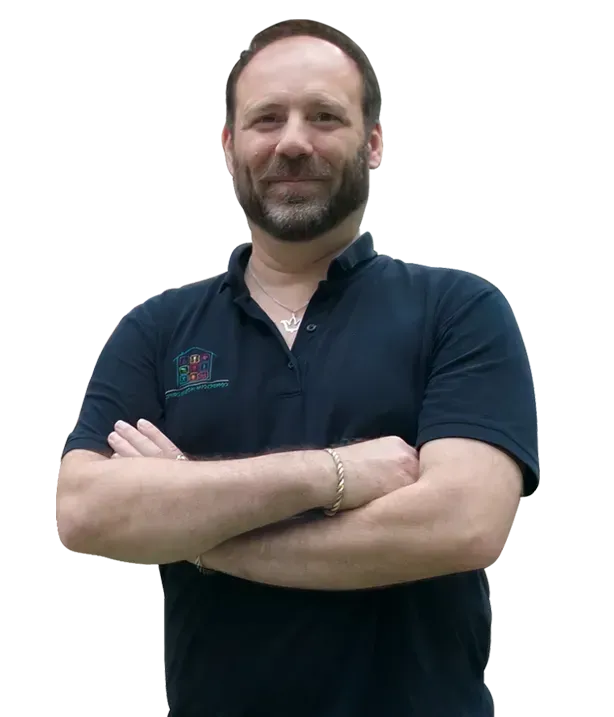 Man with folded arms in a dark navy polo shirt, standing against a white background.