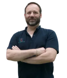Man with folded arms in a dark navy polo shirt, standing against a white background.