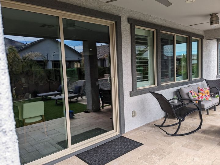 A patio with rocking chairs , a couch , and a table.