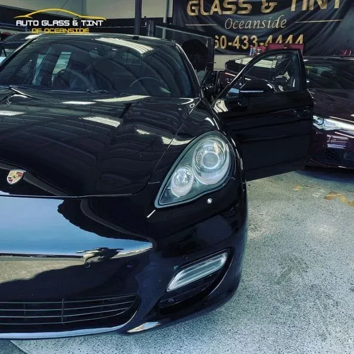 Black Porsche Panamera car with tinted windows at a auto glass and tint shop in Oceanside.