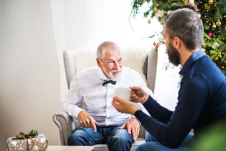 Elderly man speaking with his adult son