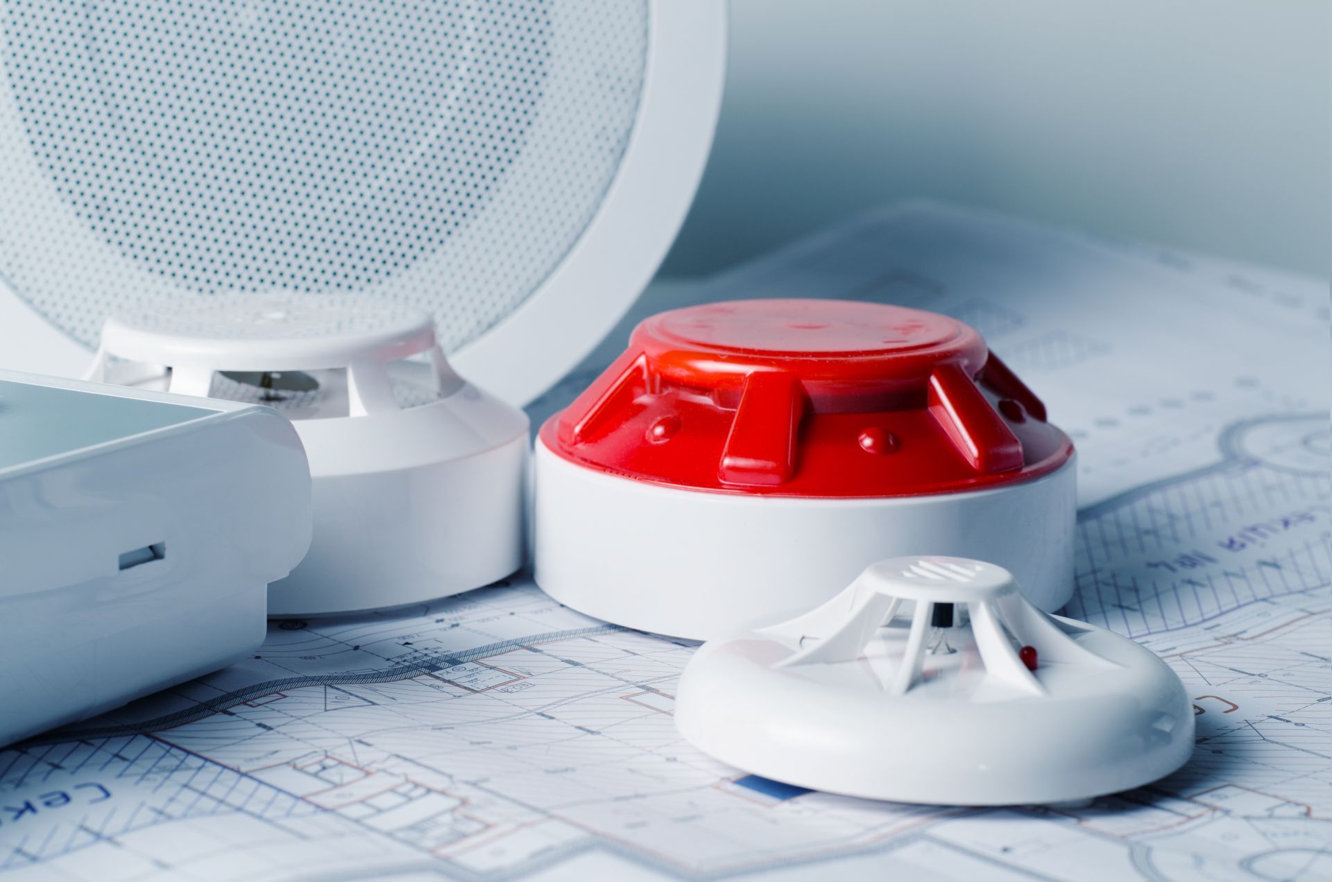 Smoke detectors on architectural plans.  A mix of white and red devices.