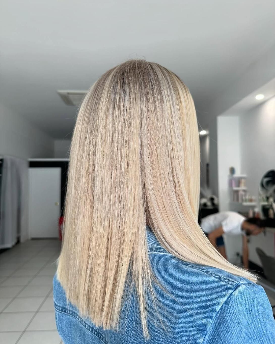 A Woman with Long Blonde Hair Is Wearing a Blue Denim Jacket — Losh Hair Lounge In Toowoomba City, QLD