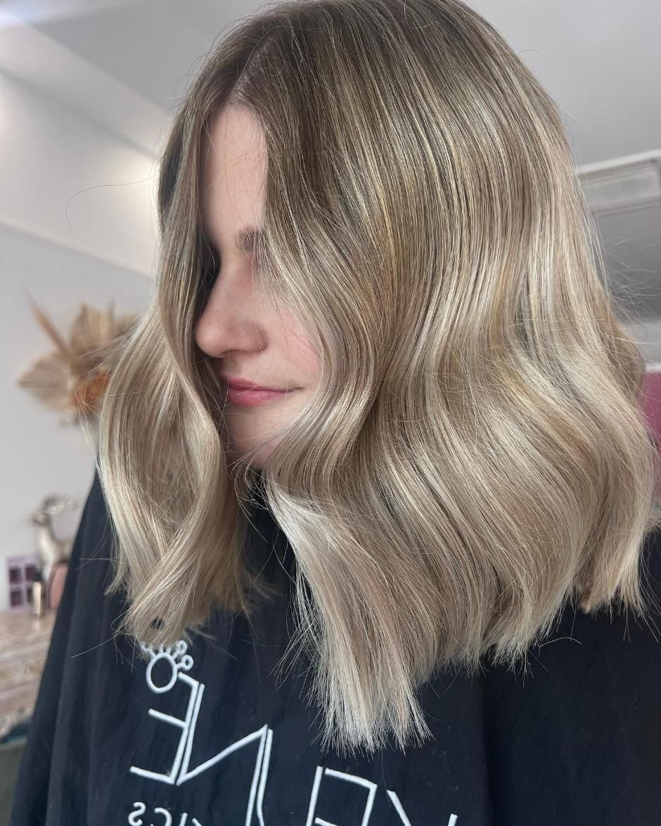 A Woman with Blonde Hair Is Wearing a Black Sweatshirt — Losh Hair Lounge In Toowoomba City, QLD