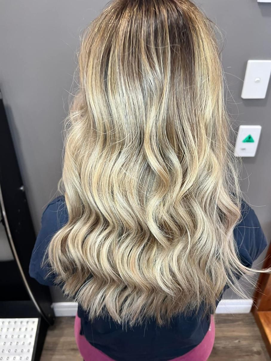 A Woman with Long Blonde Hair Is Sitting in A Room — Losh Hair Lounge In Toowoomba City, QLD