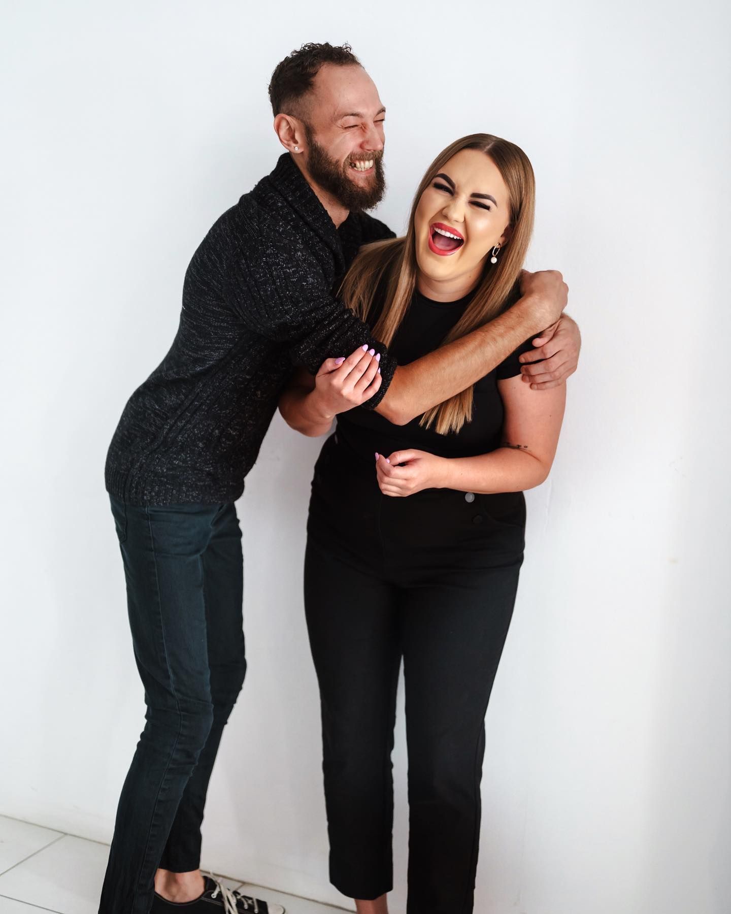 A Man Is Hugging a Woman Who Is Laughing — Losh Hair Lounge In Toowoomba City, QLD
