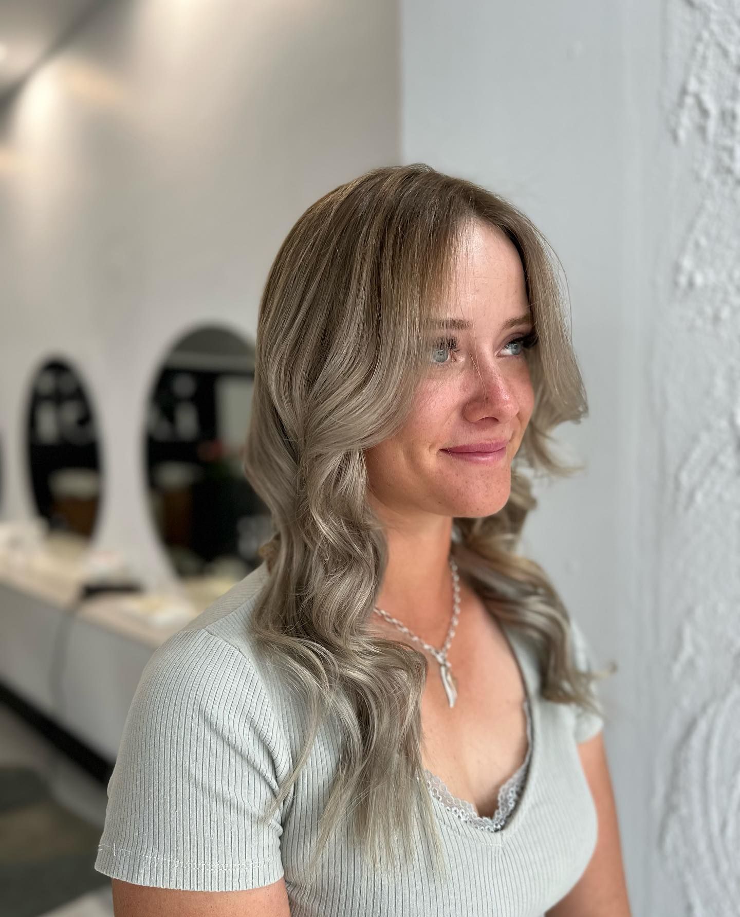 A Woman with Long Red Hair Is Sitting in A Chair in Front of A Mirror — Losh Hair Lounge In Toowoomba City, QLD