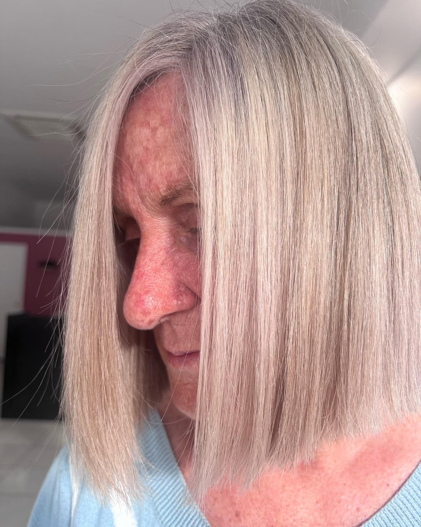 A Woman with Long Blonde Hair Is Wearing a Blue Sweater — Losh Hair Lounge In Toowoomba City, QLD