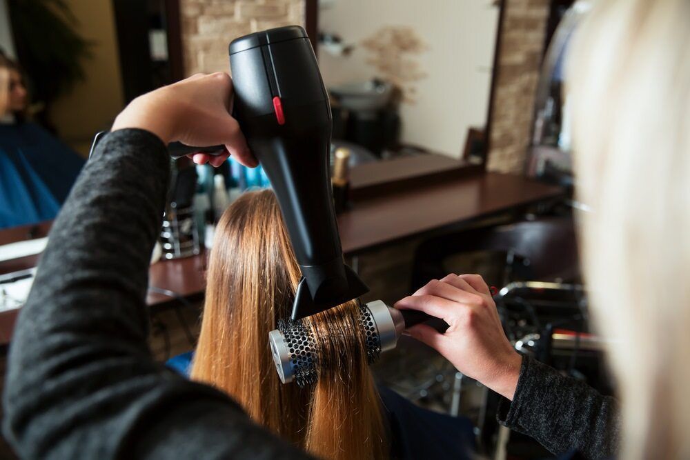 A Woman is Getting Her Hair Blow Dried by a Hairdresser in a Salon — Losh Hair Lounge In Toowoomba City, QLD