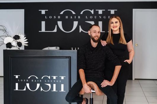 A Man and A Woman Are Standing in Front of A Sign that Says Lush Hair Lounge — Losh Hair Lounge In Toowoomba City, QLD