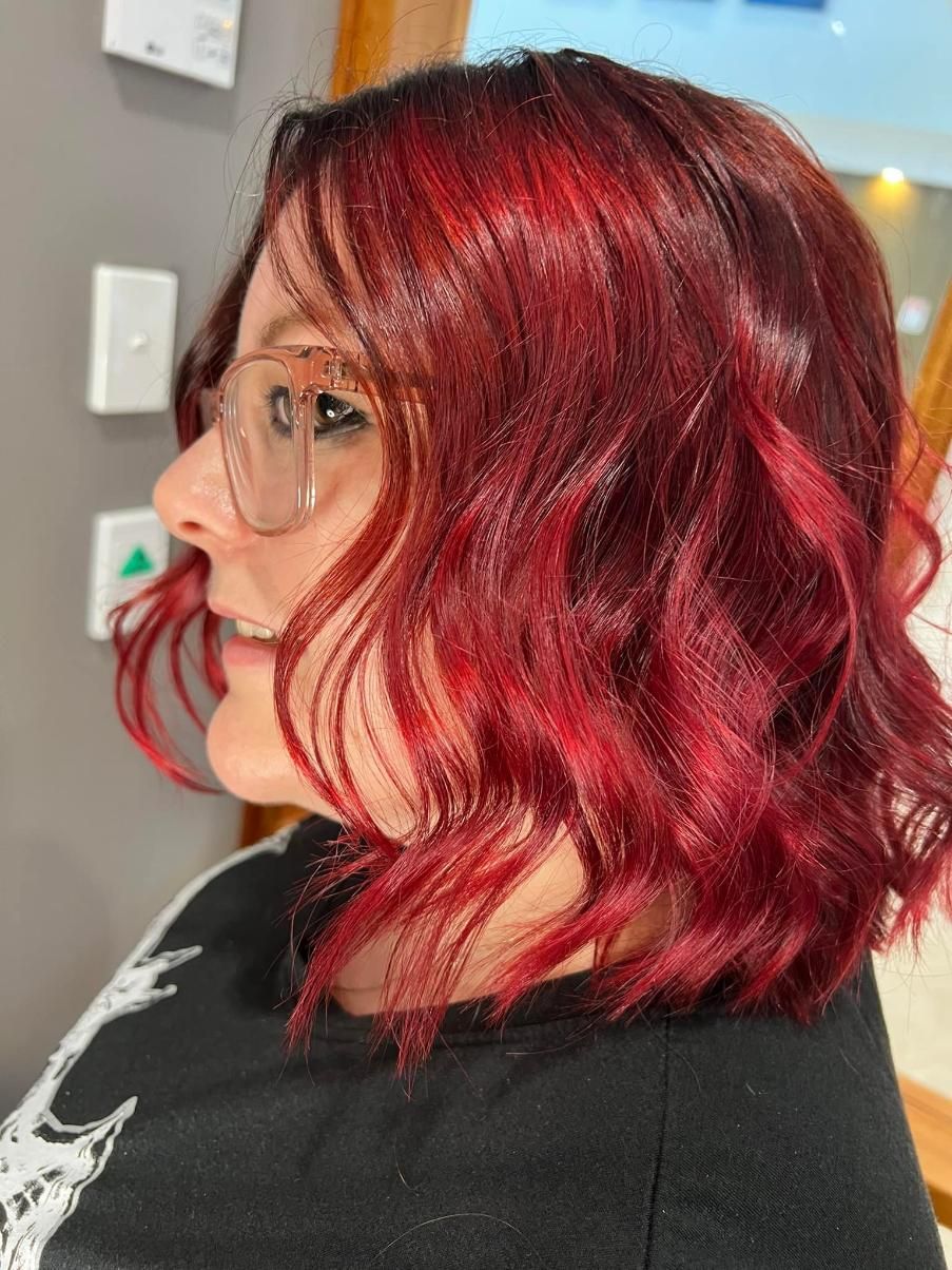A Woman with Red Hair and Glasses Is Wearing a Black Shirt — Losh Hair Lounge In Toowoomba City, QLD
